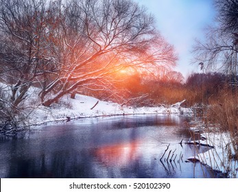 Paisaje invernal junto a un río al atardecer. reflejo del espejo