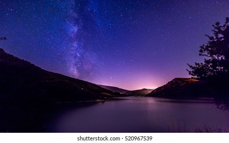 lila Sterne des Nachthimmels über dem Bergsee. Milchstraßengalaxie in der sternenklaren Nacht des Sommers