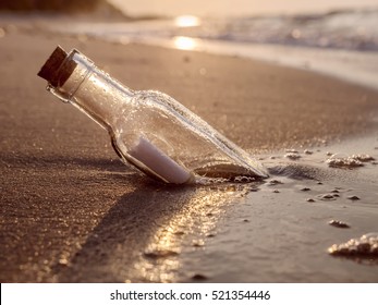 Mensaje en la botella arrastrada a tierra contra la puesta del sol