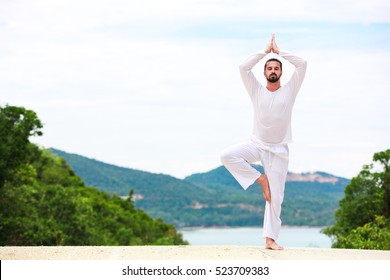 Mand laver indisk klassisk yoga ved havet og bjergene