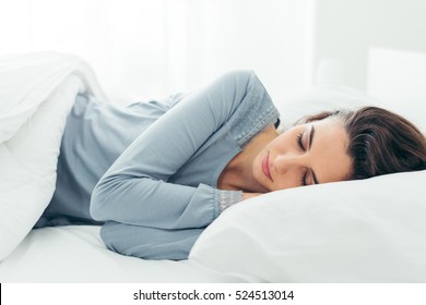 Junge schöne Frau, die in ihrem Bett schläft und sich morgens entspannt
