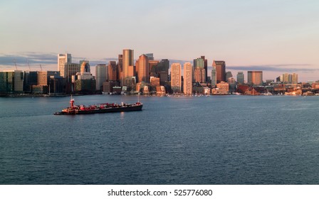 Sunrise on downtown Boston with barge on the Harbor