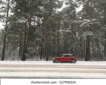 De autorit in het sneeuwbos. Mini Cooper op de weg maakte een stop. Vooraanzicht van rode mini cooper S geparkeerd in de weg. Mini Cooper bij het accelereren op de snelweg. Gezicht op een BMW Mini Cooper, 2007-modus