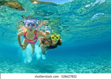 Happy family - mother with baby girl dive underwater with fun in sea pool. Healthy lifestyle, active parent, people water sport outdoor adventure, swimming lessons on beach summer holidays with child