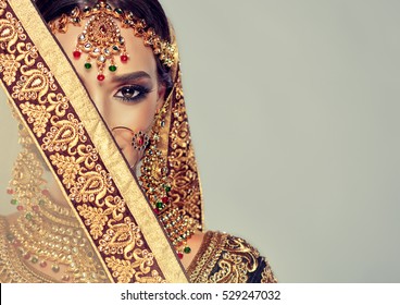 Porträt des schönen indischen Mädchens. Junges hinduistisches Frauenmodell mit goldenem Kundanschmucksatz. Traditionelle indische Tracht Lehenga Choli.