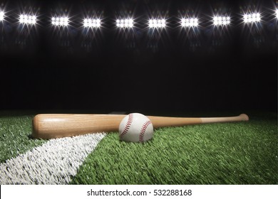 白いストライプの芝生のフィールドでスタジアムのライトの下で夜に野球とバット