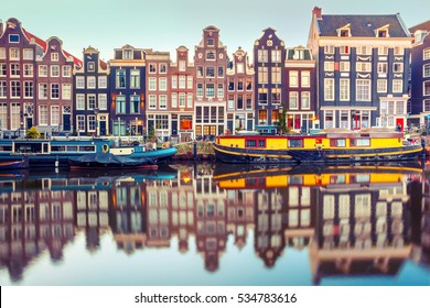 Amsterdam canal Singel with typical dutch houses and houseboats during morning blue hour, Holland, Netherlands. Used toning.