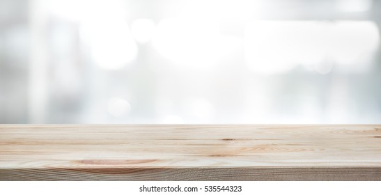 Mesa de madera sobre fondo de construcción de pared de ventana de vidrio borroso. Para exhibición de producto de montaje o fondo de diseño visual clave de diseño.