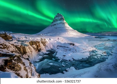 northern lights appear over Mount Kirkjufell in Iceland.