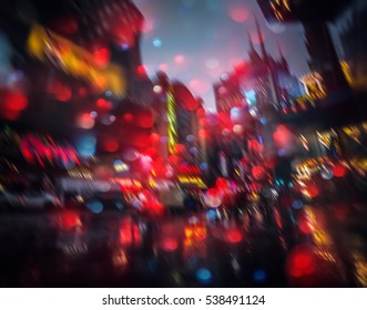 Abstraktno zamegljeno urbano ozadje. Luči in sence New Yorka. Ulice New Yorka po dežju z odsevi na mokrem asfaltu. Silhuete ljudi, ki hodijo po ulici.