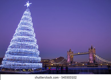 Uitzicht op de prachtige Tower Bridge met een verlichte kerstboom in Londen.