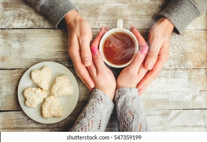 tea lovers ' hands. On wooden background.