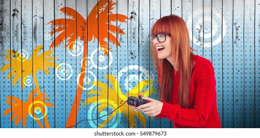 Smiling hipster woman playing video games against wooden planks background