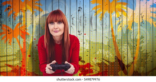 Smiling hipster woman playing video games against wooden planks background