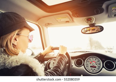 Hipstervrouw die in een kleine auto zitten