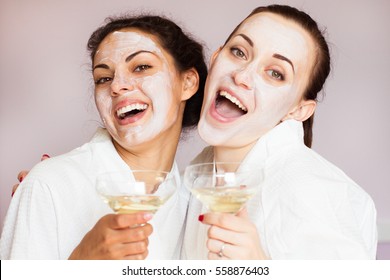Novias sonrientes con champán en el salón de spa