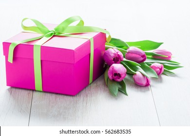 Pink Tulip Flowers and Pink Gift box on rustic table for March 8, International Womens Day, Birthday , Valentines Day or Mothers day