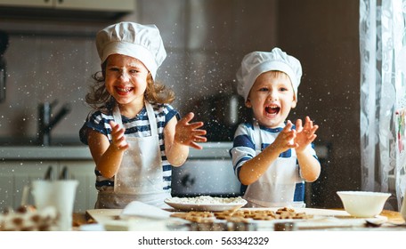 glückliche Familie lustige Kinder bereiten den Teig vor, backen Kekse in der Küche