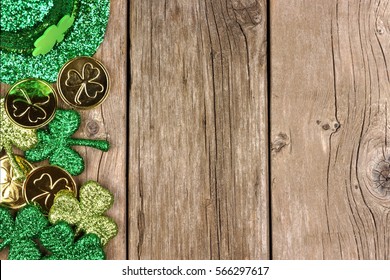 Perbatasan sisi St Patricks Day dari shamrock, koin emas, dan topi leprechaun di atas kayu pedesaan