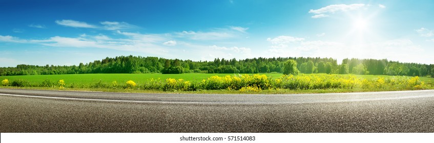 panorama de la carretera asfaltada en el campo en el soleado día de primavera