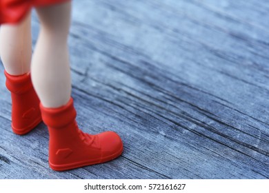 Close up model toys wearing red boots on the wooden background