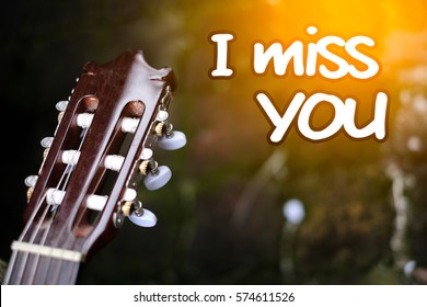 Imej berkonsepkan gitar yang mengandungi perkataan I miss you dengan latar belakang oren kabur yang bagus