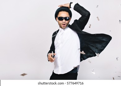 スーツ、帽子、白い背景で楽しんでいる黒いサングラスで肯定的な興奮したハンサムな男。ヘッドホンで音楽を聴く、踊る、歌う、祝賀会、幸せ