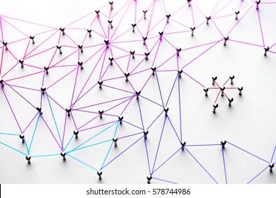 Entidades interligadas. Redes, mídias sociais, redes sociais, comunicação pela internet (resumo). Pequena rede conectada a uma rede maior. Teia de fios em tons de azul claro a escuro, vermelho, roxo e dourado sobre fundo branco.