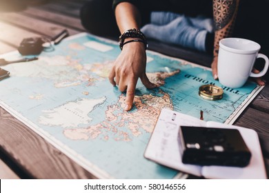 Vacaciones de planificación turística con la ayuda del mapa mundial con otros accesorios de viaje. Mujer joven apuntando a América del Norte en el mapa mundial.