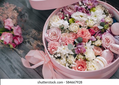 Macarons im Karton. Geschenk zum Frauentag (8. März), Frauentag. Muttertag. Valentinstag. Festliche runde rosa Box mit handgefertigten Macarons und Rose. auf hölzernem Hintergrund