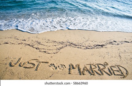 Recién casados ​​escritos en la arena de la playa