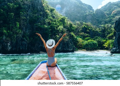 ボートでリラックスし、島を見て帽子の若い女性の背面図。アジアの旅行ツアー: エルニド、パラワン、フィリピン。