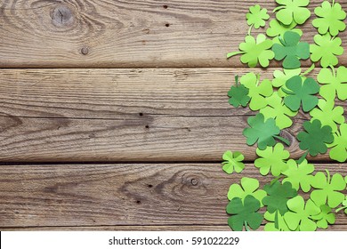 Daun semanggi kertas pada latar belakang kayu tua. Lucky shamrock, simbol hari libur St.Patrick. Spasi untuk teks, tampilan atas.