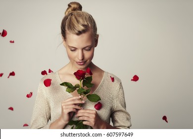 Bella mujer con pétalos de rosas rojas, estudio