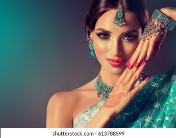 Porträtlächeln des schönen indischen Mädchens. Junges indisches Frauenmodell mit blauem Schmuckset. Saree in traditioneller indischer Tracht.