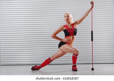 Horizontale volledige lengte shot van een mooie blonde vrouwelijke fitness model trainen met training stick pronken met haar sterke lichaam en perfecte abs copyspace sport dieet vrouwelijkheid atleet.