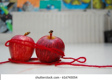 două mere apropiate împreună cu un fir roșu al destinului