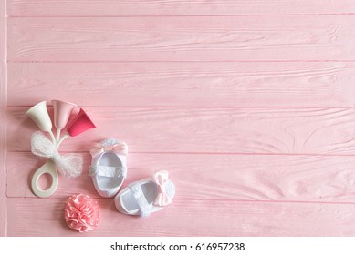 Nyfødt baby pige baggrund. Nyfødt tilbehør til en babypige på en lyserød træbaggrund.