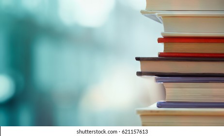 Book stack in the library room and blurred bookshelf for business and education background, back to school concept