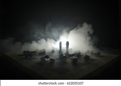 Schachbrettspiel-Konzept von Geschäftsideen und Wettbewerbs- und Strategieideen-Konzept. Schachfiguren auf einem dunklen Hintergrund mit Rauch und Nebel. Selektiver Fokus