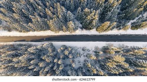 Coche negro en la carretera en un hermoso paisaje invernal, desde un dron.