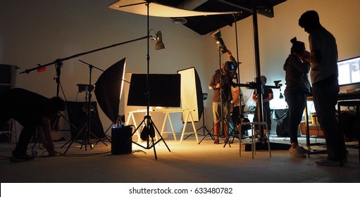 Hinter dem Drehteam der Produktionsmannschaft und der Silhouette von Kamera und Ausrüstung im Studio.