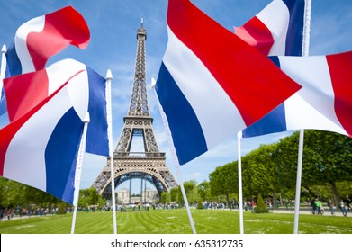 フランス、パリのエッフェル塔の明るい春の景色の前をはためくトリコロールのフランス国旗