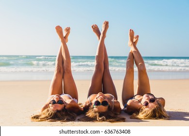 砂の上に横たわるビーチで 3 人の美しい女の子