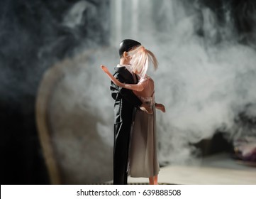 Los novios de muñecas en el interior se abrazan. Chica hermosa modelo en vestido blanco. Hombre de traje Concepto de amor de boda. De cerca, fumar en el fondo. Enfoque selectivo
