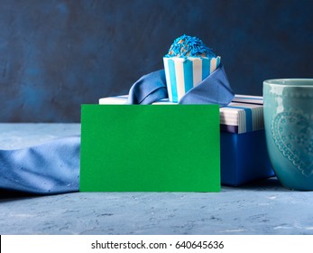 Vatertagskarte mit Geschenkbox und Tasse Kuchen, Krawatte, Tasse Kaffee auf blauem Hintergrund. Grünes leeres Papier