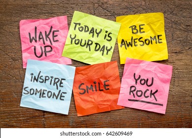 wake up, be awesome, inspire someone, smile, you rock - set of inspirational sticky notes against rustic wood