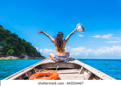 Happy woman traveler in bikini relaxing on boat her arms open feeling freedom, Andaman sea, Surin island, Phangnga,Travel in Thailand, Beautiful destination Asia, Summer holiday outdoors vacation trip