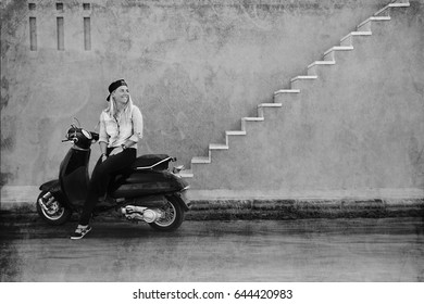 Schattig meisje in jeans shirt en pet zittend op een motor, straat portret in zomervakantie tijd in vintage stijl, actieve levensstijl, recreatie en plezier, muur met trappen achtergrond, zwart-wit