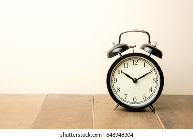 窓の近くにある黒いヴィンテージの目覚まし時計は、10時から10時を示しています